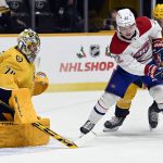 
              Montreal Canadiens right wing Cole Caufield (22) and Nashville Predators defenseman Dante Fabbro (57) vie for the puck in front of Predators goaltender Juuse Saros (74) during the first period of an NHL hockey game Saturday, Dec. 4, 2021, in Nashville, Tenn. (AP Photo/Mark Zaleski)
            