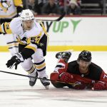 
              New Jersey Devils defenseman Dougie Hamilton (7) hits the ice as Pittsburgh Penguins center Teddy Blueger (53) chases the puck during the first period of an NHL hockey game Sunday, Dec.19, 2021, in Newark, N.J. (AP Photo/Bill Kostroun)
            