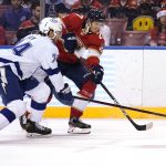 
              Florida Panthers center Eetu Luostarinen, right, passes the puck as Tampa Bay Lightning defenseman Sean Day (74) defends during the second period of an NHL hockey game, Thursday, Dec. 30, 2021, in Sunrise, Fla. (AP Photo/Lynne Sladky)
            