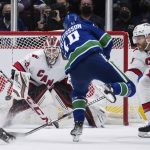 
              Vancouver Canucks' Elias Pettersson (40), of Sweden, scores against Carolina Hurricanes goalie Antti Raanta (32), of Finland, as Ian Cole (28) defends during the second period of an NHL hockey game in Vancouver, British Columbia, Sunday, Dec. 12, 2021. (Darryl Dyck/The Canadian Press via AP)
            