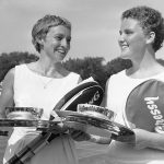 
              FILE - Darlene Hard, left, of the United States, and partner Lesley Turner, of Australia, pose for photos after winning the women's U.S. Lawn Tennis Association women's doubles championship at Longwood Cricket Club in Brookline, Mass., Aug. 28, 1961. Hard, an aggressive serve-and-volley player who won three major singles titles as well as 18 major doubles titles in a Hall of Fame tennis career, died Thursday, Dec. 2, 2021, after a brief illness. She was 85. (AP Photo/Bill Chaplis, File)
            