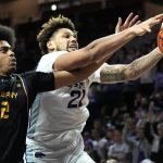 
              Albany's Justin Neely (12) and Kansas State's Davion Bradford (21) chase a rebound during the first half of an NCAA college basketball game Wednesday, Dec. 1, 2021, in Manhattan, Kan. (AP Photo/Charlie Riedel)
            