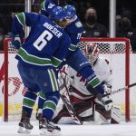 
              Carolina Hurricanes goalie Antti Raanta, back, of Finland, stops Vancouver Canucks' Brock Boeser (6) as Tanner Pearson (70) jumps in front of him during the second period of an NHL hockey game in Vancouver, British Columbia, Sunday, Dec. 12, 2021. (Darryl Dyck/The Canadian Press via AP)
            