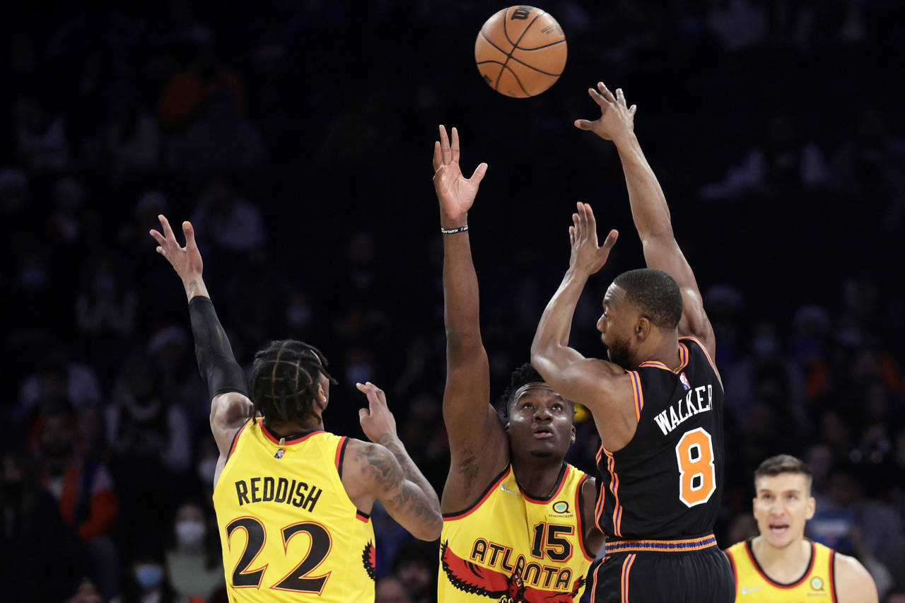New York Knicks guard Kemba Walker (8) passes over Atlanta Hawks center Clint Capela (15) during th...