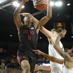 
              San Diego State forward Keshad Johnson (0) dunks on Michigan center Hunter Dickinson (1) and Eli Brooks (55) in the first half of an NCAA college basketball game in Ann Arbor, Mich., Saturday, Dec. 4, 2021. (AP Photo/Paul Sancya)
            