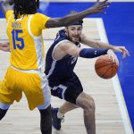 
              Monmouth guard George Papas, right, looks to get off a pass with Pittsburgh forward Mouhamadou Gueye (15) defending during the first half of an NCAA college basketball game in Pittsburgh, Sunday, Dec. 12, 2021. (AP Photo/Gene J. Puskar)
            