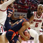 
              Virginia's Taylor Valladay (2) is trapped with the ball between North Carolina State's Raina Perez (2) and Jada Boyd (5) during the first half of an NCAA college basketball game, Sunday, Dec. 19, 2021, in Raleigh, N.C. (AP Photo/Karl B. DeBlaker)
            