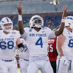 
              Air Force quarterback Haaziq Daniels (4) celebrates a touchdown run against Louisville as offensive tackle Mark Heistand (68) looks on during the first half of the First Responder Bowl NCAA college football game Tuesday, Dec. 28, 2021, in Dallas. (AP Photo/Jeffrey McWhorter)
            
