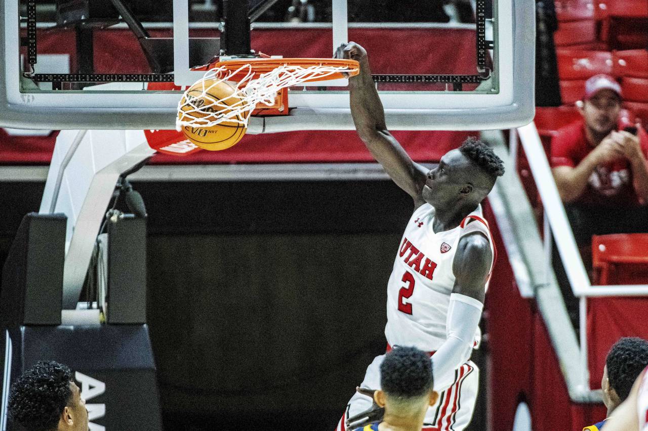 Utah guard Both Gach (2) dunks during the first half of an NCAA college basketball game against Cal...