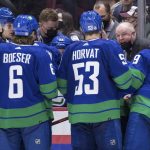 
              Vancouver Canucks head coach Bruce Boudreau, back right, talks to Elias Pettersson, of Sweden, from left to right, Brock Boeser, Bo Horvat and J.T. Miller during a timeout during the third period of an NHL hockey game  against the Columbus Blue Jackets Tuesday, Dec. 14, 2021 in Vancouver, British Columbia. (Darryl Dyck/The Canadian Press via AP)
            