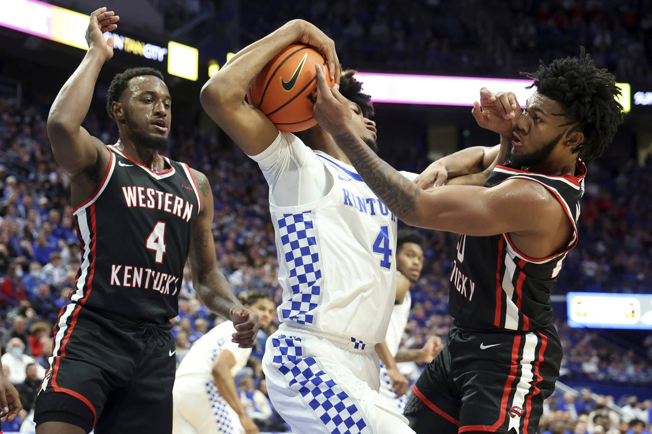 Kentucky's Daimion Collins, middle, pulls down a rebound between Western Kentucky's Josh Anderson, ...