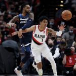 
              Minnesota Timberwolves guard D'Angelo Russell, left, and Portland Trail Blazers guard Anfernee Simons, right, battle for a loose ball during the first half of an NBA basketball game in Portland, Ore., Sunday, Dec. 12, 2021. (AP Photo/Steve Dipaola)
            