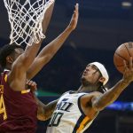 
              Utah Jazz's Jordan Clarkson (00) drives to the basket again Cleveland Cavaliers' Evan Mobley (4) in the first half of an NBA basketball game, Sunday, Dec. 5, 2021, in Cleveland. (AP Photo/Tony Dejak)
            