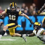 
              Iowa wide receiver Charlie Jones (16) runs from Michigan defensive back Brad Hawkins (2) during the first half of the Big Ten championship NCAA college football game, Saturday, Dec. 4, 2021, in Indianapolis. (AP Photo/AJ Mast)
            