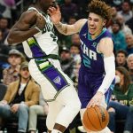 
              Charlotte Hornets' LaMelo Ball tries to get past Milwaukee Bucks' Jrue Holiday during the first half of an NBA basketball game Wednesday, Dec. 1, 2021, in Milwaukee. (AP Photo/Morry Gash)
            