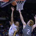 
              LSU guard Xavier Pinson (1) shoots against Lipscomb guard Will Pruitt (2) during the first half of an NCAA college basketball game in Baton Rouge, La., Wednesday, Dec. 22, 2021. (AP Photo/Matthew Hinton)
            