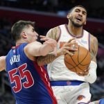
              New York Knicks guard Tyler Hall is defended by Detroit Pistons center Luka Garza (55) during the second half of an NBA basketball game, Wednesday, Dec. 29, 2021, in Detroit. (AP Photo/Carlos Osorio)
            