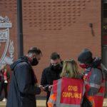 
              Stewards check the fans for their COVID-19 documents at the entrance of Anfield stadium before the English Premier League soccer match between Liverpool and Newcastle United in Liverpool, England, Thursday, Dec. 16, 2021. (AP Photo/Jon Super)
            
