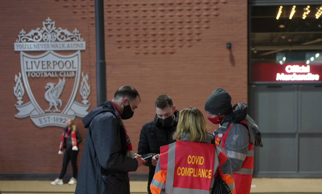 Stewards check the fans for their COVID-19 documents at the entrance of Anfield stadium before the ...