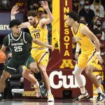 
              Michigan State guard Malik Hall (25) tries to drive past Minnesota forward Jamison Battle (10) as guard Payton Willis watches during the first half an NCAA college basketball game Wednesday, Dec. 8, 2021, in Minneapolis. (AP Photo/Craig Lassig)
            