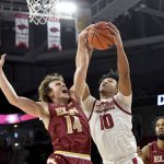 
              Arkansas forward Jaylin Williams (10) and Elon guard Zac Ervin (14) vie for a rebound during the first half of an NCAA college basketball game Tuesday, Dec. 21, 2021, in Fayetteville, Ark. (AP Photo/Michael Woods)
            