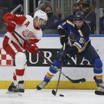 
              Detroit Red Wings' Danny DeKeyser (65) and St. Louis Blues' Dakota Joshua (54) vie for control of the puck during the second period of an NHL hockey game Thursday, Dec. 9, 2021, in St. Louis. (AP Photo/Scott Kane)
            