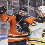 
              Boston Bruins' John Moore (27) checks Edmonton Oilers' Warren Foegele (37) during second-period NHL hockey game action in Edmonton, Alberta, Thursday, Dec. 9, 2021. (Amber Bracken/The Canadian Press via AP)
            