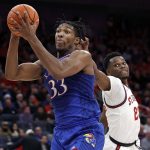 
              Kansas forward David McCormack (33) drives to the basket past St. John's guard Montez Mathis during the first half of an NCAA college basketball game Friday, Dec. 3, 2021, in Elmont, N.Y. (AP Photo/Adam Hunger)
            