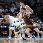 
              Vanderbilt's Tyrin Lawrence tries to get past Loyola's Ryan Schwieger (13) in the second half of an NCAA college basketball game Friday, Dec. 10, 2021, in Nashville, Tenn. (AP Photo/Mark Humphrey)
            