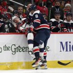 
              Washington Capitals left wing Alex Ovechkin (8) checks Columbus Blue Jackets defenseman Andrew Peeke (2) into the Capitals' bench area during the second period of an NHL hockey game, Saturday, Dec. 4, 2021, in Washington. (AP Photo/Nick Wass)
            