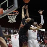 
              Southern California guard Boogie Ellis, center, shoots between Washington State guards TJ Bamba (5) and Noah Williams, right, during the first half of an NCAA college basketball game, Saturday, Dec. 4, 2021, in Pullman, Wash. (AP Photo/Young Kwak)
            