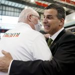 
              Miami's new football coach, Mario Cristobal, right, is embraced by Miami men's basketball coach Jim Larranaga, left, after being introduced at a news conference Tuesday, Dec. 7, 2021, in Coral Gables, Fla. Cristobal is returning to his alma mater, where he won two championships as a player. (AP Photo/Lynne Sladky)
            