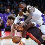 
              Los Angeles Lakers forward LeBron James, front, fights for a ball against Orlando Magic center Robin Lopez during the first half of an NBA basketball game in Los Angeles, Sunday, Dec. 12, 2021. (AP Photo/Ringo H.W. Chiu)
            