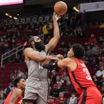 
              Brooklyn Nets guard James Harden, left, passes as Houston Rockets center Christian Wood defends during the first half of an NBA basketball game, Wednesday, Dec. 8, 2021, in Houston. (AP Photo/Eric Christian Smith)
            