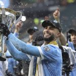 
              New York City FC forward Valentin Castellanos (11) celebrates with the trophy after their penalty kick shootout win over the Portland Timbers in the MLS Cup soccer game, Saturday, Dec. 11, 2021, in Portland, Ore. (AP Photo/Amanda Loman)
            