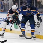 
              Edmonton Oilers' Zach Hyman (18) and St. Louis Blues' Vladimir Tarasenko (91) battle for a loose puck during the third period of an NHL hockey game Wednesday, Dec. 29, 2021, in St. Louis. (AP Photo/Jeff Roberson)
            