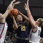 
              Notre Dame's Anaya Peoples looks to shoot under pressure from Connecticut's Caroline Ducharme, left, and Connecticut's Dorka Juhász, right, in the first half of an NCAA college basketball game, Sunday, Dec. 5, 2021, in Storrs, Conn. (AP Photo/Jessica Hill)
            