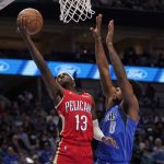 
              New Orleans Pelicans guard Kira Lewis Jr. (13) shoots as Dallas Mavericks forward Sterling Brown (0) defends during the first half of an NBA basketball game in Dallas, Friday, Dec. 3, 2021. (AP Photo/Tony Gutierrez)
            