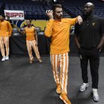 
              Tennessee basketball players and coaches stand around near the court after an NCAA basketball game was cancelled due to COVID-19 protocols within the Memphis program on Saturday, Dec. 18, 2021, in Nashville, Tenn. (AP Photo/Mark Zaleski)
            