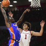 
              Florida forward Anthony Duruji (4) goes up for a dunk against Oklahoma guard Jalen Hill (1) during the first half of an NCAA college basketball game in Norman, Okla., Wednesday, Dec. 1, 2021. (AP Photo/Kyle Phillips)
            