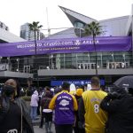 
              Fans stand outside Crypto.com Arena before an NBA basketball game between the Brooklyn Nets and the Los Angeles Lakers in Los Angeles, Saturday, Dec. 25, 2021. The arena's name officially changed from Staples Center to Crypto.com Arena. (AP Photo/Ashley Landis)
            
