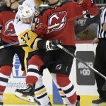 
              Pittsburgh Penguins center Sidney Crosby (87) slows up New Jersey Devils left wing Janne Kuokkanen (59) during the first period of an NHL hockey game, Sunday, Dec. 19, 2021, in Newark, N.J. (AP Photo/Bill Kostroun)
            