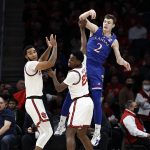 
              Kansas guard Christian Braun (2) passes the ball over St. John's guard Montez Mathis during the first half of an NCAA college basketball game Friday, Dec. 3, 2021, in Elmont, N.Y. (AP Photo/Adam Hunger)
            