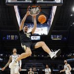 
              Purdue center Zach Edey (15) dunks the ball ahead of Butler forward Ty Groce, left, during the first half of an NCAA college basketball game, Saturday, Dec. 18, 2021, in Indianapolis. (AP Photo/AJ Mast)
            