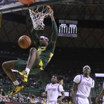 
              Baylor forward Flo Thamba, left, dunks over Alcorn State center Lenell Henry in the first half of an NCAA college basketball game, Monday, Dec. 20, 2021, in Waco, Texas. (AP Photo/Rod Aydelotte)
            