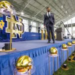 
              New Notre Dame NCAA college football head coach Marcus Freeman is shown on stage after answering questions during an introductory press conference Monday, Dec. 6, 2021, at the Irish Athletic Center in South Bend., Ind. (Michael Caterina/South Bend Tribune via AP)
            