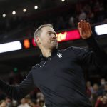 
              Southern California head football coach Lincoln Riley throws a t-shirt to a fan after he is introduced to the basketball fans during the first half of an NCAA college basketball game against Long Beach State in Los Angeles, Sunday, Dec. 12, 2021. (AP Photo/Alex Gallardo)
            
