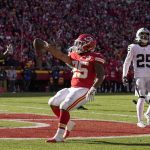 
              Kansas City Chiefs running back Clyde Edwards-Helaire, left, celebrates after scoring past Las Vegas Raiders safety Tre'von Moehrig, right, during the first half of an NFL football game Sunday, Dec. 12, 2021, in Kansas City, Mo. (AP Photo/Charlie Riedel)
            