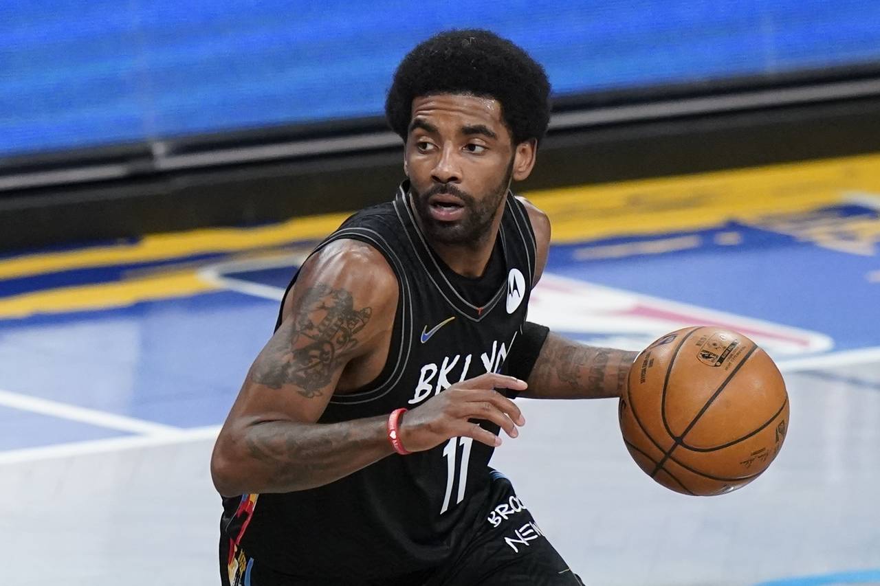 FILE - Brooklyn Nets' Kyrie Irving moves the ball during the first half of an NBA basketball game a...