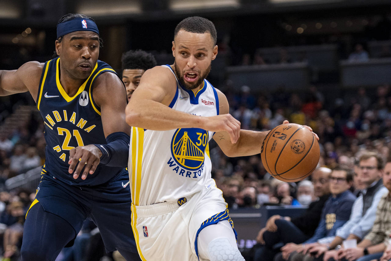 Golden State Warriors guard Stephen Curry (30) drives the ball past the defense of Indiana Pacers g...